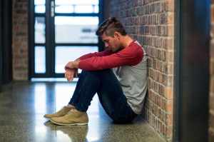 Man sitting against a wall